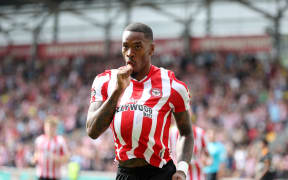 Ivan Toney of Brentford celebrates and hides the ball after scoring.