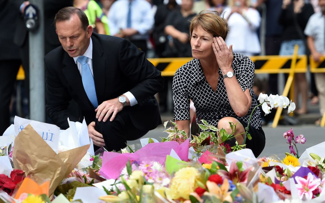 Prime Minister Tony Abbott and wife Margie join thousands of Sydneysiders to lay flowers near the cafe.