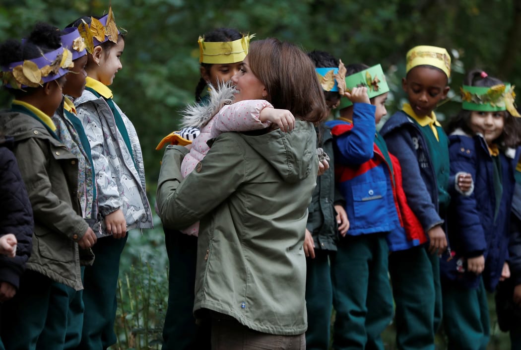 Britain's Catherine, Duchess of Cambridge (R), receives a hug from four-year-old Amwaar, as she says goodbye to school children after visiting to Sayers Croft Forest School and Wildlife Garden in London.