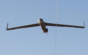 A 29 June 2011 US Army handout shows a ScanEagle surveillance drone flying into a retrieval wire at Camp Taji, Iraq.