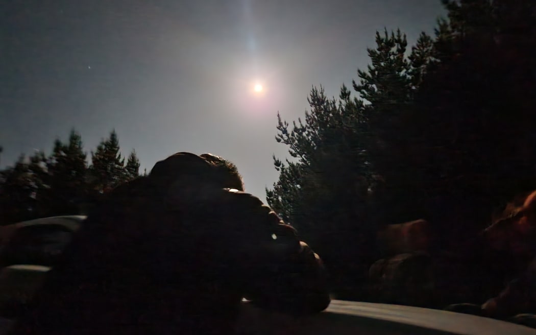 Wayne lines up a shot in the light of the full moon