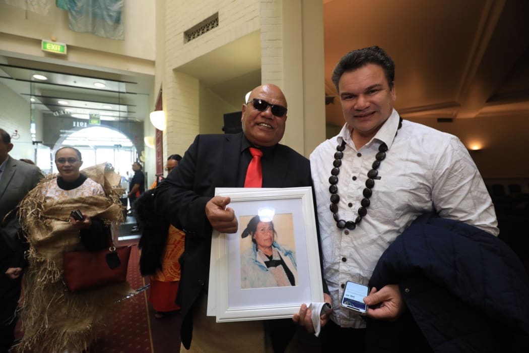 Melino Maka (L) holds picture of his aunt Teresia Tobbing who was raided in February 1976 in Onehunga.  La'auli Sir Michael Jones (R)
