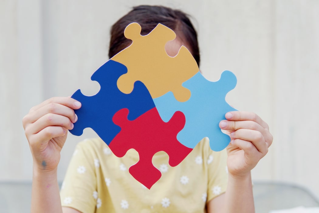 Kid girl hands holding puzzle jigsaw,  mental health concept, world autism awareness day