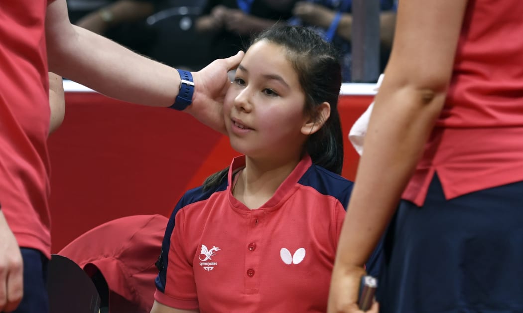 Eleven-year-old table tennis player Anna Hursey of Wales (C) is congratulated by coach Steven Jenkins (L) and teammate Charlotte Carey (R) after winning her women's doubles match at the 2018 Gold Coast Commonwealth Games on April 5, 2018. / AFP PHOTO / William WEST