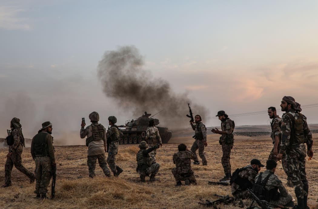 Turkish soldiers and Turkey-backed Syrian fighters gather on the northern outskirts of the Syrian city of Manbij near the Turkish border as Turkey and its allies continue their assault on Kurdish-held border towns in northeastern Syria.