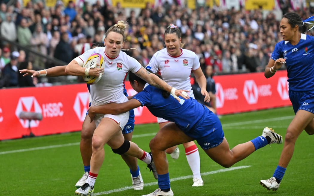 England's centre Megan Jones (L) runs in another try during the Women’s Rugby World Cup pool A match between England and Samoa at Franklin's Gardens, Northampton, central England, on August 30, 2025. (Photo by Glyn KIRK / AFP)