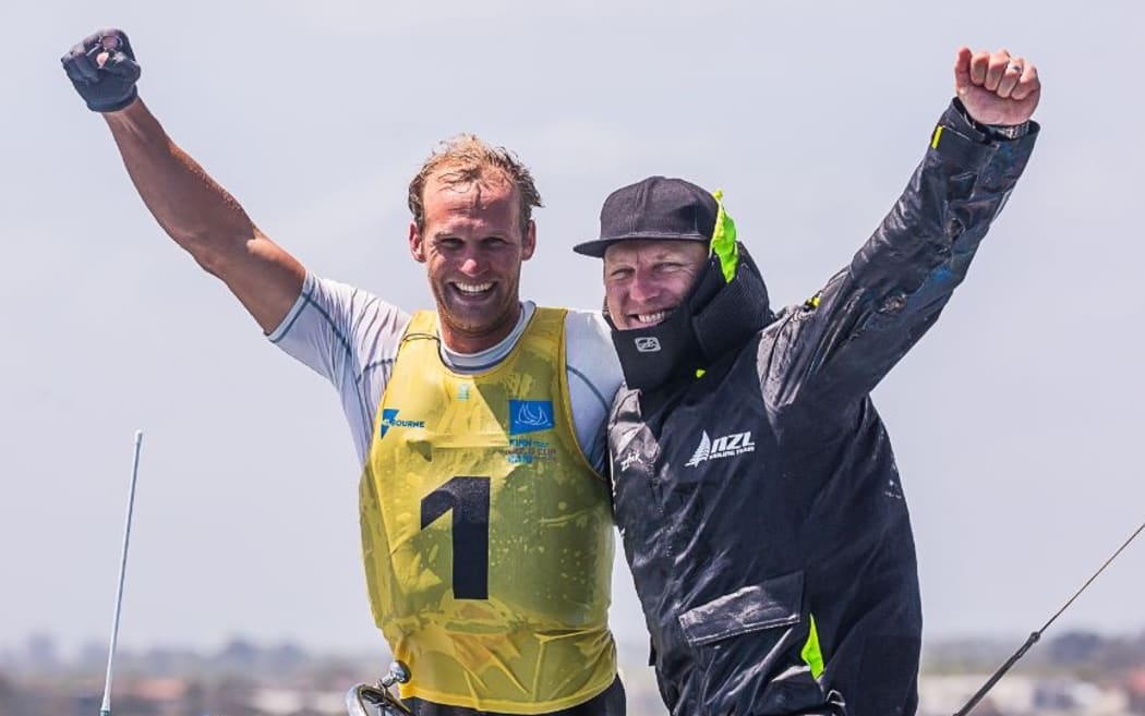 Josh Junior celebrates with coach Andrew Murdoch after becoming the first Kiwi to win the Finn World Champs.