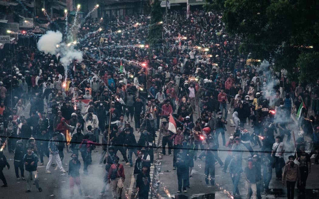 A firework explodes during a labour union protest for lawmakers to improve working conditions, near the Parliament in Jakarta on August 28, 2025. (Photo by YASUYOSHI CHIBA / AFP)
