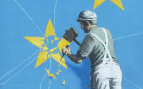 Banksy Brexit mural of man chipping away at EU flag