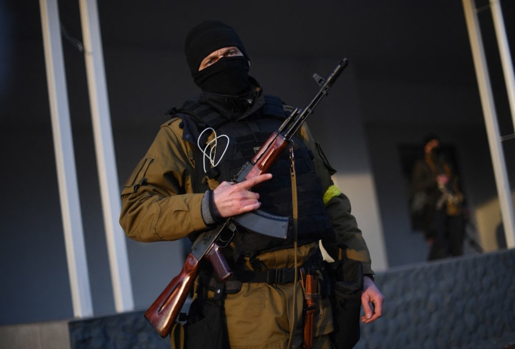 EDITORS NOTE: Graphic content / Armed civilian volunteers stand alert on a street in Kyiv on February 25, 2022. - Russian forces reached the outskirts of Kyiv on February 25, as Ukrainian President said the invading troops were targeting civilians