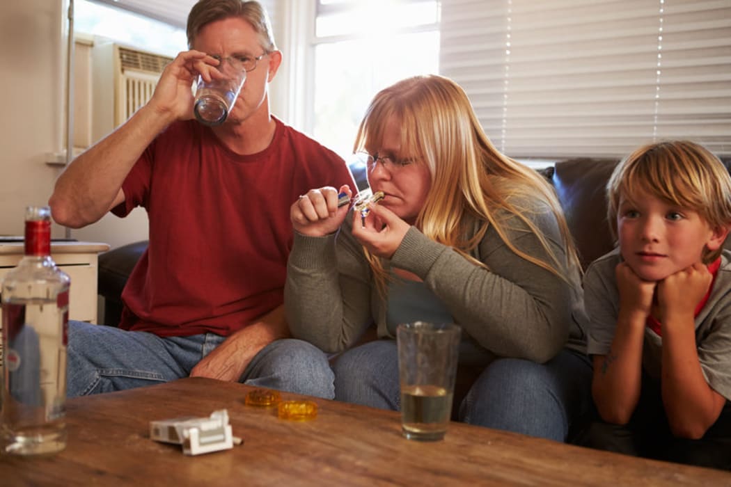 A family with mother taking drugs and father drinking.