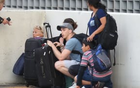 Passengers take cover as first responders secure the area outside the Fort Lauderdale-Hollywood International airport.