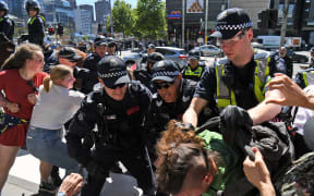 Police arrest a climate change protester outside the International Mining and Resources Conference (IMARC) being held in Melbourne on 29 October, 2019.