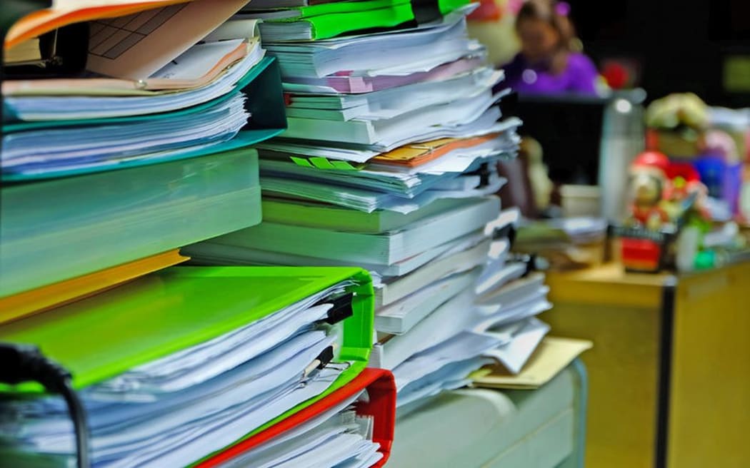 Pile of paperwork in folders on desk (stock image).