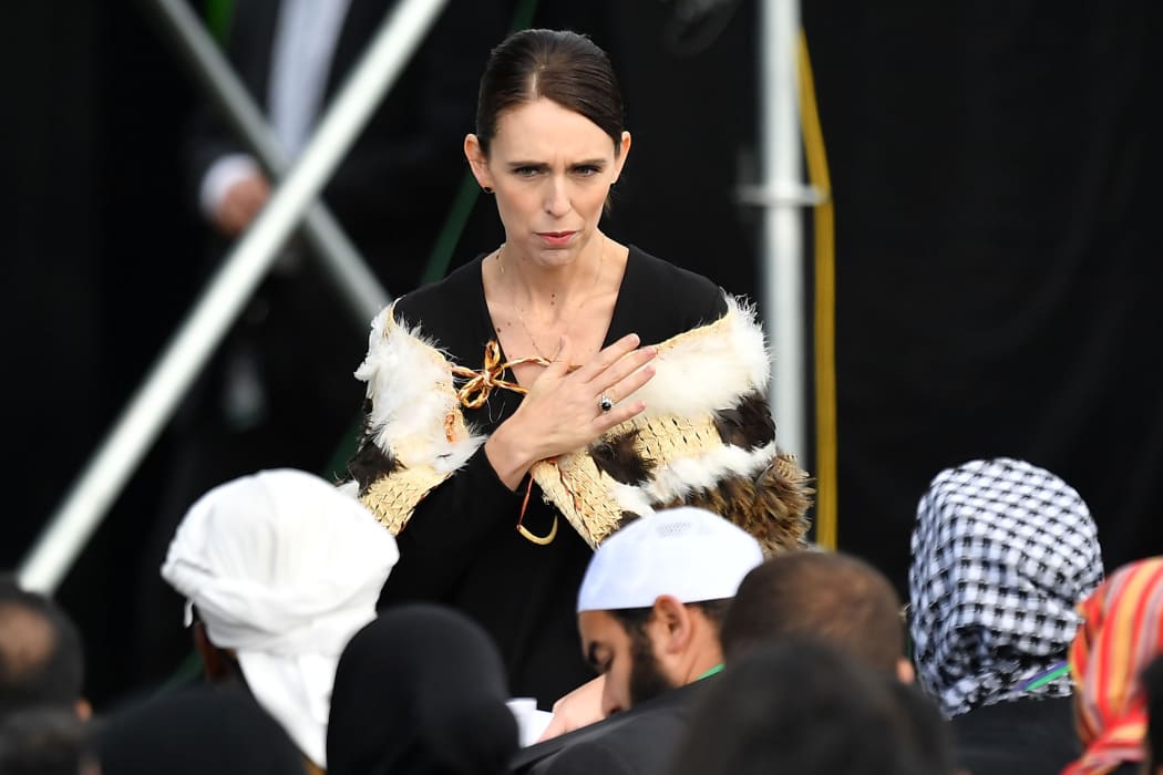Prime Minister Jacinda Ardern places her hand over her heart as she walks past family members during a National Remembrance Service at Hagley Park, Christchurch, 29 March 2019.