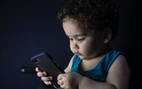 toddler with mobile phone
