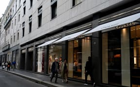 People walk past Gucci and Chanel boutiques in Via Monte Napoleone, a famous upscale shopping street in Milan, on 9 Apri, 2024.