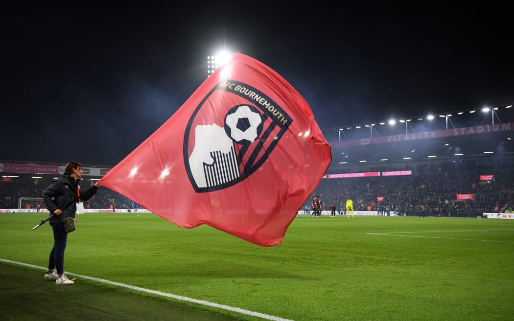 A flag bearer waves an AFC Bournemouth flag.