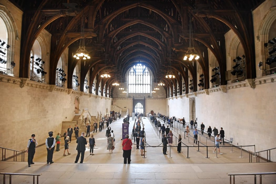 A handout photograph released by the UK Parliament shows members of parliament queuing in Westminster Hall to vote.