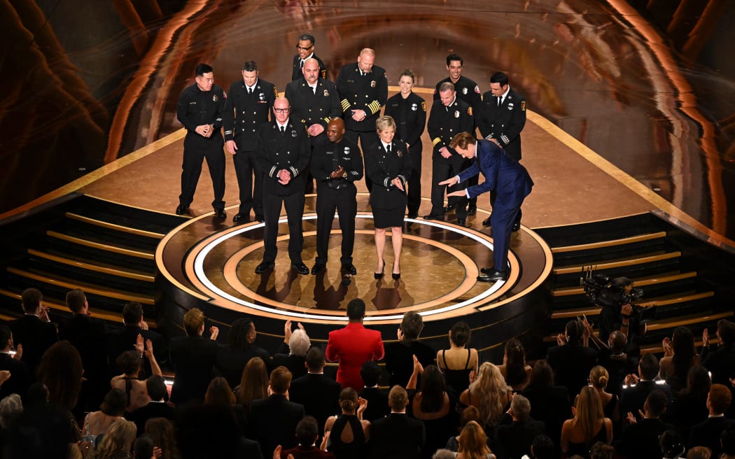 (From L) Los Angeles Fire Department (LAFD) Captain Erik Scott, LAFD helicopter pilot Jonith Johnson Jr. and Pasadena Fire Captain Jodi Slicker speak onstage next to US comedian and host Conan O'Brien during the 97th Annual Academy Awards at the Dolby Theatre in Hollywood, California on March 2, 2025. (Photo by Patrick T. Fallon / AFP)