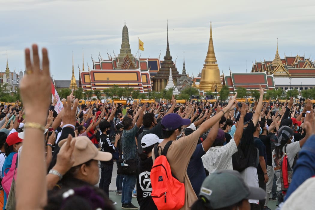 Pro-democracy protesters hold up the three-finger salute on Sanam Luang field next to the Grand Palace in Bangkok on September 20, 2020
