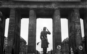 A Soviet Red army woman soldier controls traffic in front of the Brandenburg Gate, in July 1945 in Berlin.