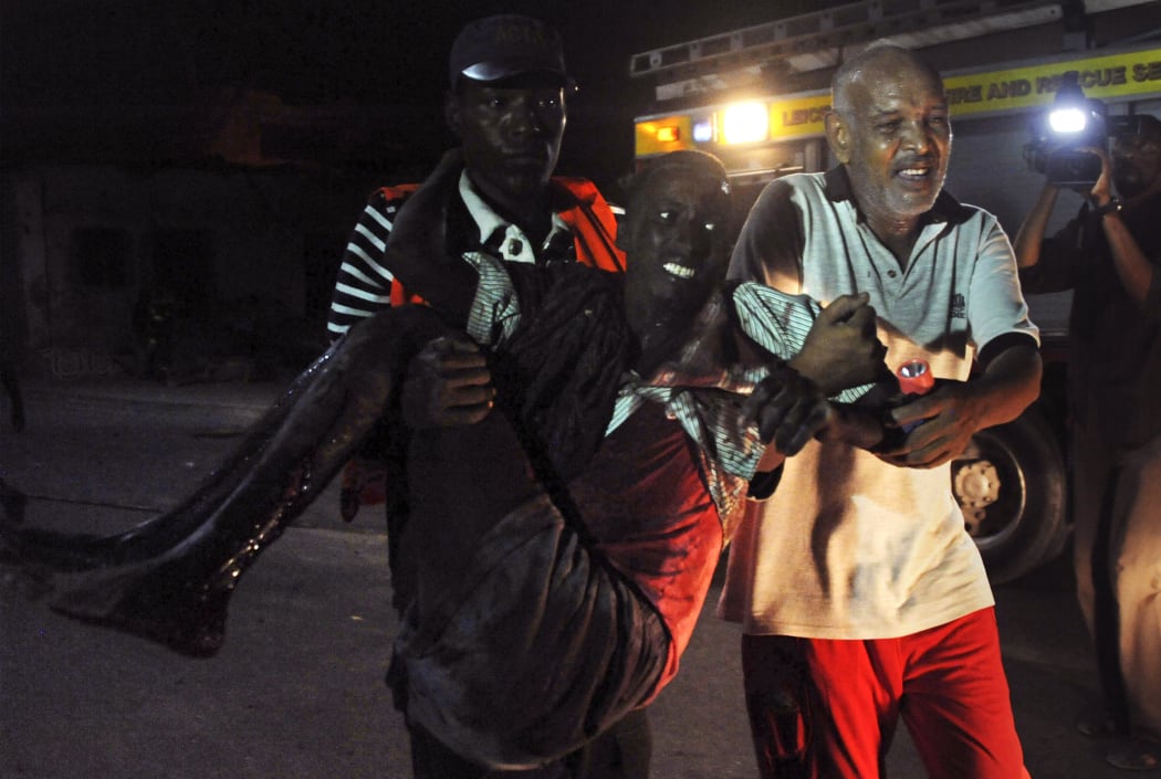 Residents help a man wounded during an attack in the center of Mogadishu on 26 February 2016.