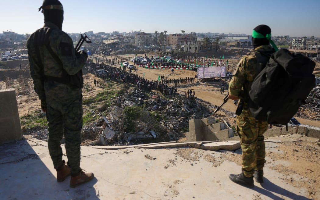 Hamas militants keep watch from a building over an area before handing over two Israeli hostages to a Red Cross team in Khan Yunis, southern Gaza Strip, on February 15, 2025, as part of the hostage-prisoner exchange. Gaza militants are due to release three Israeli hostages on February 15 in exchange for 369 Palestinians in Israeli custody, the latest swap of a truce that came close to collapse this week. (Photo by Bashar TALEB / AFP)