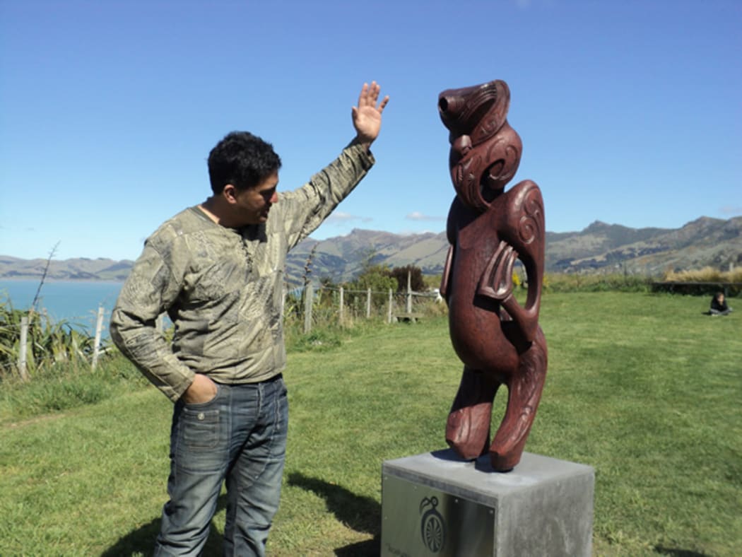 Caine Tauwhare with the pou, Kōauau o Tāne Whakapiripiri.