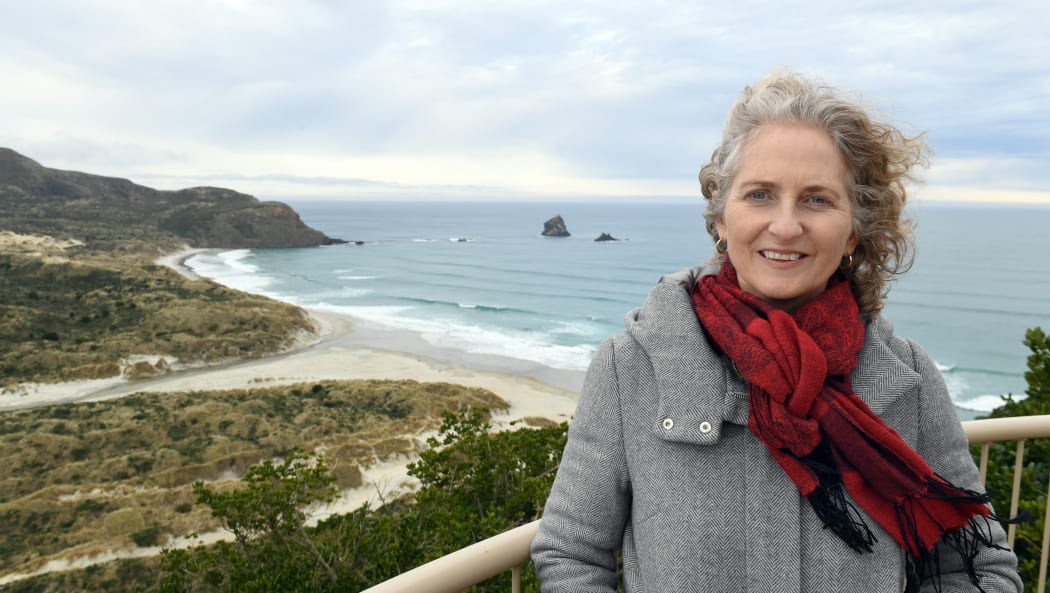 For the penguins sake . . .  Reasearchers have suggested closing off beaches to allow penguins to breed in peace. Yolanda van Heezik with Sandfly bay in behind.
