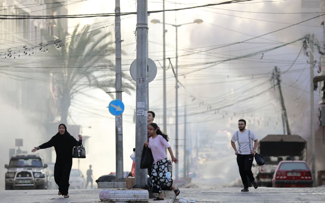 Palestinians run for cover after a strike near the Al-Shifa hopsital in Gaza City on 1 November 2023, amid the ongoing battles between Israel and the Palestinian group Hamas.