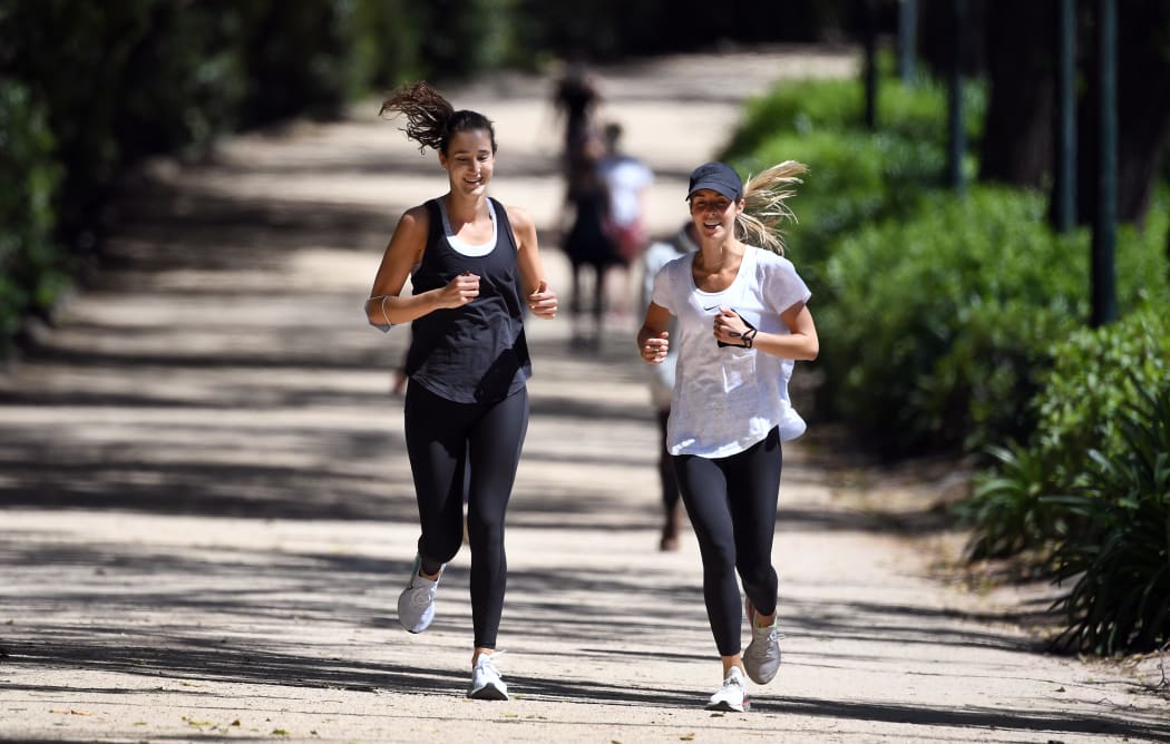 People jog on a running track around Melbourne's Royal Botanic Gardens on 16 October 2020.
