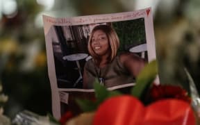 The portrait of a victim is displayed among candles and flowers on the doorsteps of the Notre-Dame de l'Assomption Basilica in Nice on October 30, 2020, a day after a knife attacker killed three people