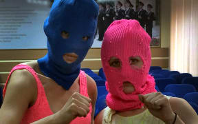 Wearing their signature ski-masks, Pussy Riot members Nadezhda Tolokonnikova (left) and Maria Alyokhina pose for a photo in a police station after their arrest on Tuesday.