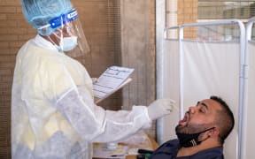 A healthcare worker conducts a PCR Covid-19 test at the Lancet laboratory in Johannesburg on November 30, 2021 as a new, heavily mutated Covid-19 variant, dubbed omicron, spread across the globe.