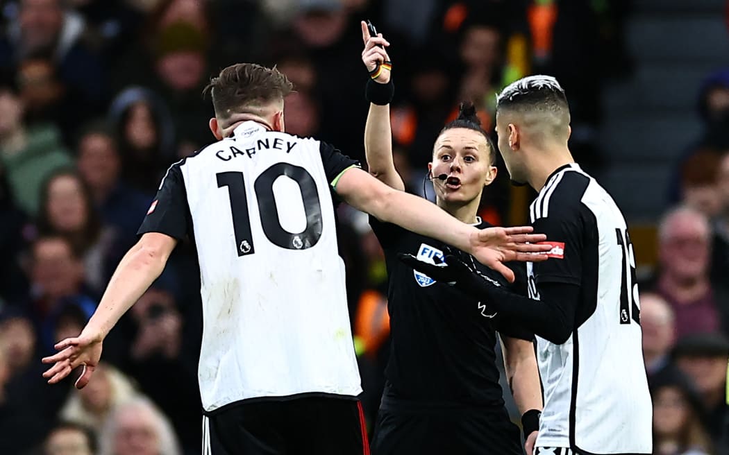 English referee Rebecca Welch (C) gestures during the English Premier League football match between Fulham and Burnley at Craven Cottage in London on December 23, 2023. Rebecca Welch becomes the first female referee of a Premier League match overseeing Fulham's game against Burnley. (Photo by HENRY NICHOLLS / AFP) / RESTRICTED TO EDITORIAL USE. No use with unauthorized audio, video, data, fixture lists, club/league logos or 'live' services. Online in-match use limited to 120 images. An additional 40 images may be used in extra time. No video emulation. Social media in-match use limited to 120 images. An additional 40 images may be used in extra time. No use in betting publications, games or single club/league/player publications. /