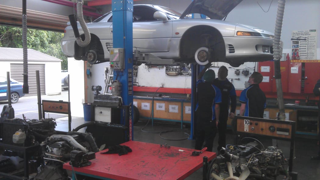 Volunteer student mechanics service a vehicle.