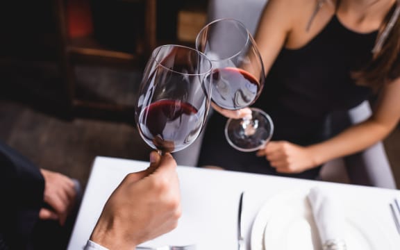 Couple clinking wine glasses.