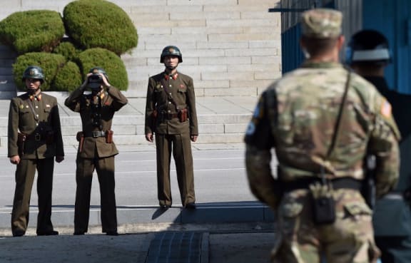 North Korean soldiers looking at the South side in a file photograph of the DMZ.