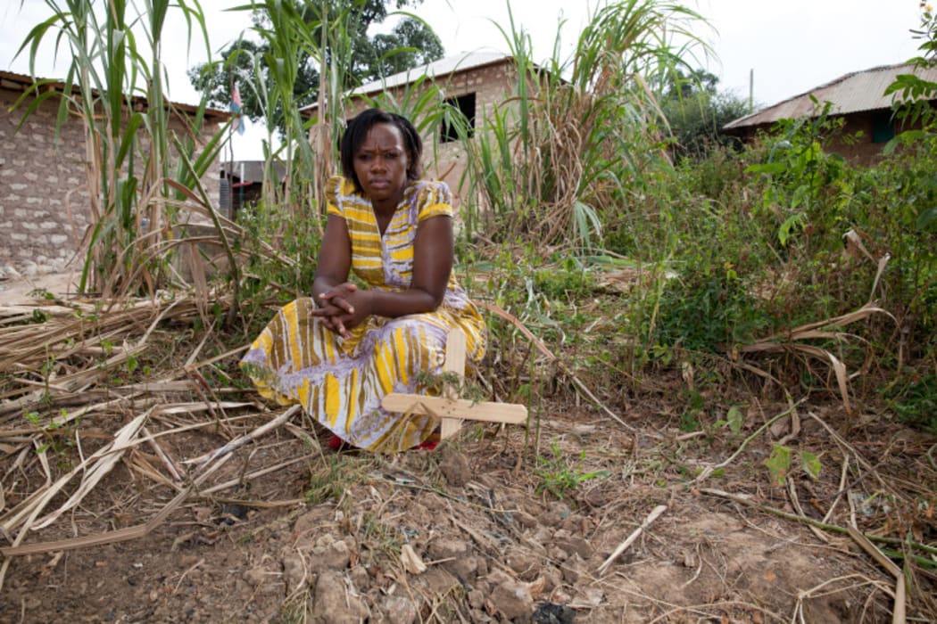 Phyllis at the grave of a 3 month old baby who had recently died as a result of lead poisoning from the factory nearby.