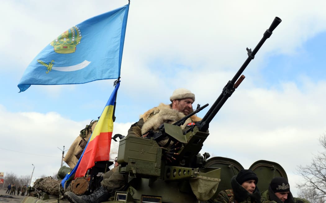 Armed pro-Russian rebels ride an Armoured Personnel Carrier in the eastern Ukrainian city of Debaltseve.