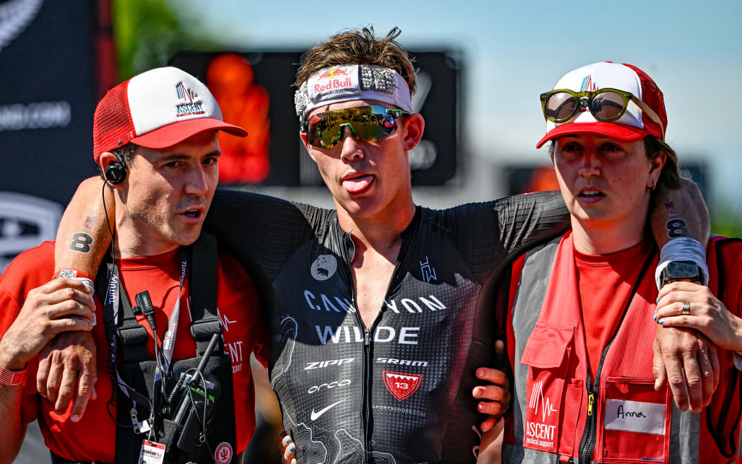 Hayden Wilde is helped off the finish line after finishing 2nd in the Ironman 70.3 World Championship Pro Men race held in Taupo, New Zealand,  2024.