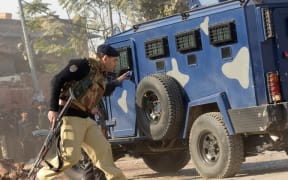 Pakistani security personnel take position outside the Agriculture Training Institute after an attack by Taliban militants.