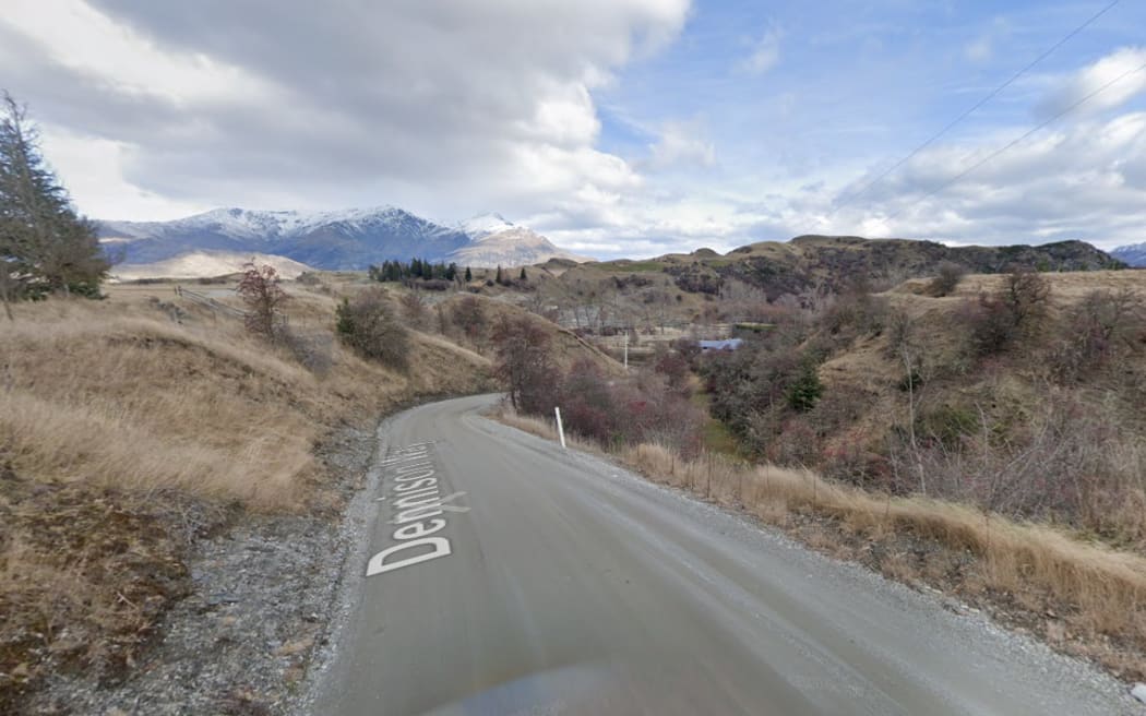 A street view of Dennison Way, it looks rural and there are snow-capped mountains in the distance.