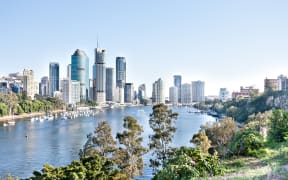 Brisbane City building with a river surrounded by trees at sunny day with blue sky Queensland, Australia.