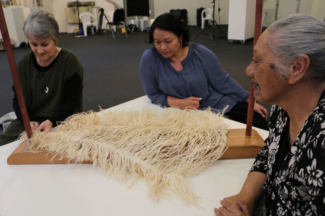 Gloria Taituha, Jacqueline McRae-Tarei and Rose Te Ratana examine a piece