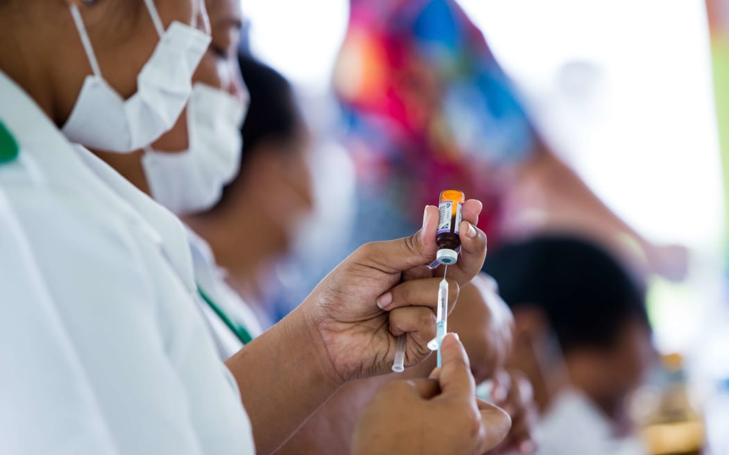 This handout picture released from UNICEF Samoa shows nurse April Wilson (L) and team leader Luisa Popo preparing vaccinations during a nationwide campaign against measles in the Samoan town of Le'auva'a.