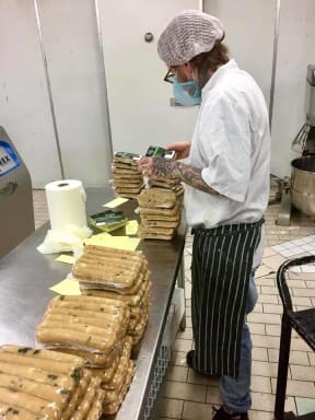 Staff putting labelling on Suzy Spoon's Vegetarian Butcher plant-based products.