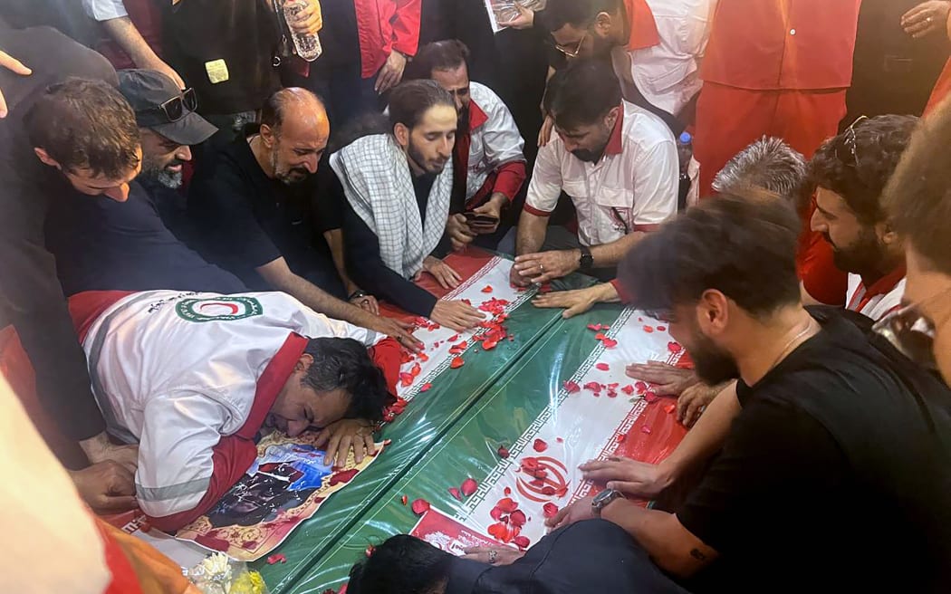 This handout picture provided by the Iranian Red Crescent on June 19, 2025 shows mourners during the funeral of two Iranian Red Crescent members who were killed the previous days during an Israeli strike in Tehran. The Iranian Red Crescent said on June 18 that an Israeli attack took place near its building in Tehran, on the sixth day of an air war between Iran and Israel, noting that the strike appeared to not be targeting the aid group. (Photo by Iranian Red Crescent / AFP) / === RESTRICTED TO EDITORIAL USE - MANDATORY CREDIT "AFP PHOTO / HO / IRANIAN RED CRESCENT" - NO MARKETING NO ADVERTISING CAMPAIGNS - DISTRIBUTED AS A SERVICE TO CLIENTS ===