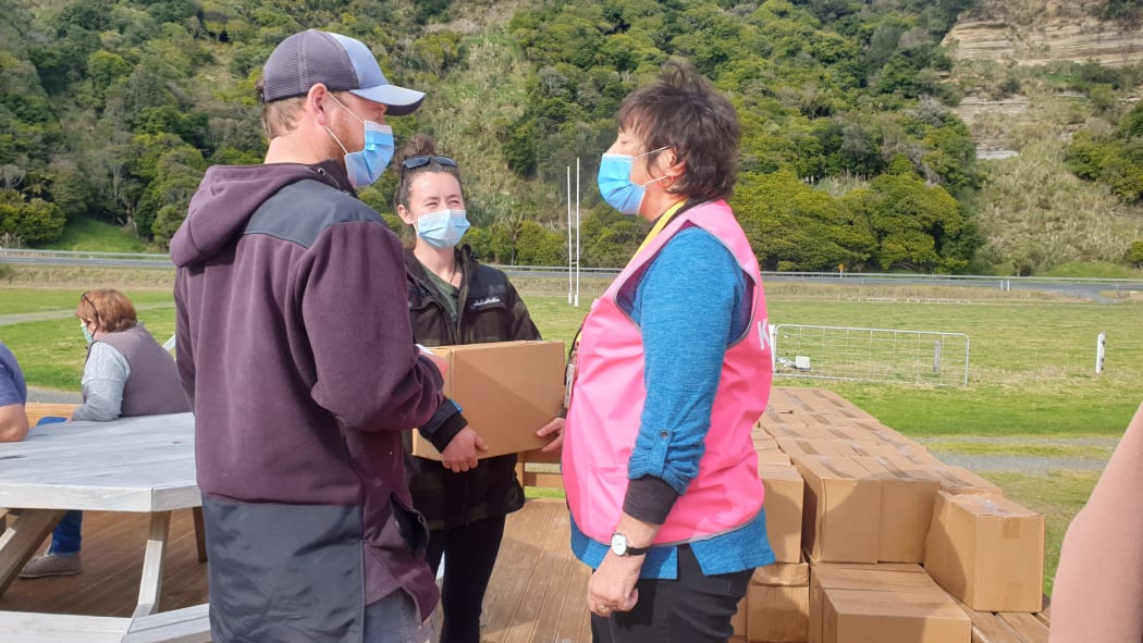 Tui Ora's Patsy Bodger hands over a care package to a couple after they have completed their observation period.